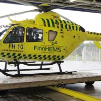 FinnHEMS helikopteri siiretään ulos hallista liikkuvalla lavetilla. 