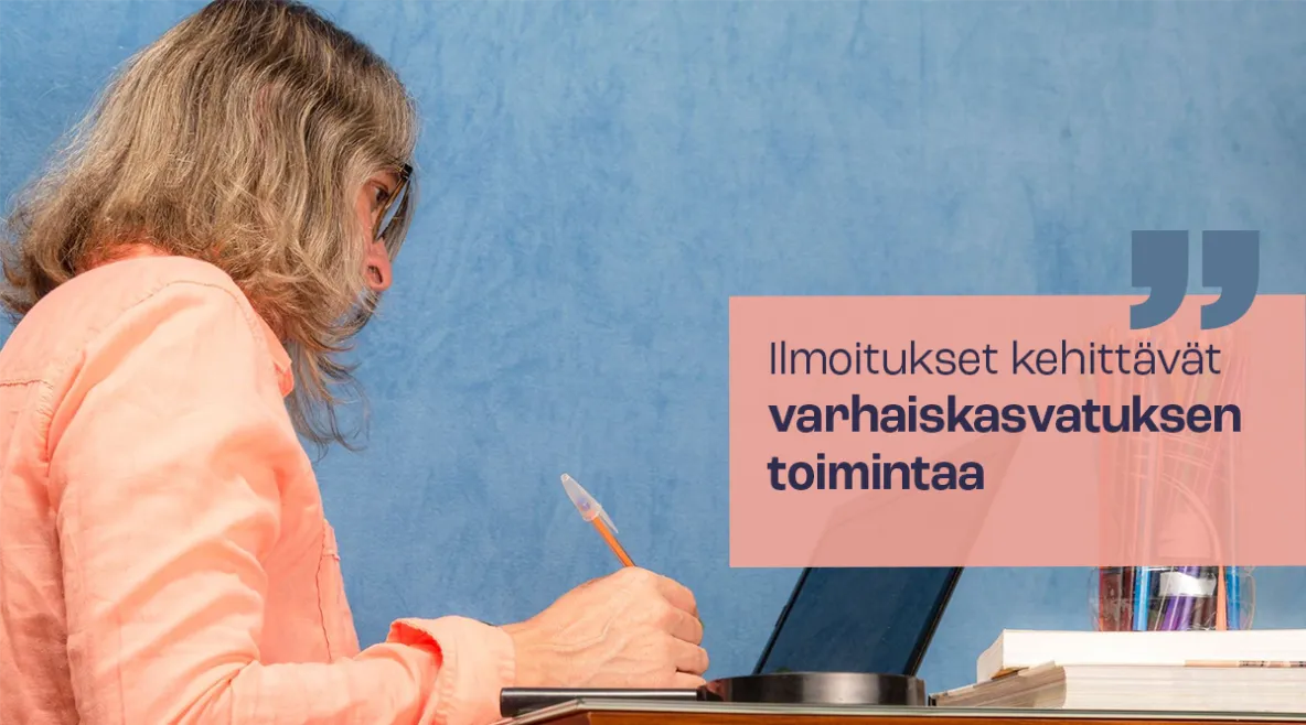 Nainen kynä kädessä tietokoneen äärellä.