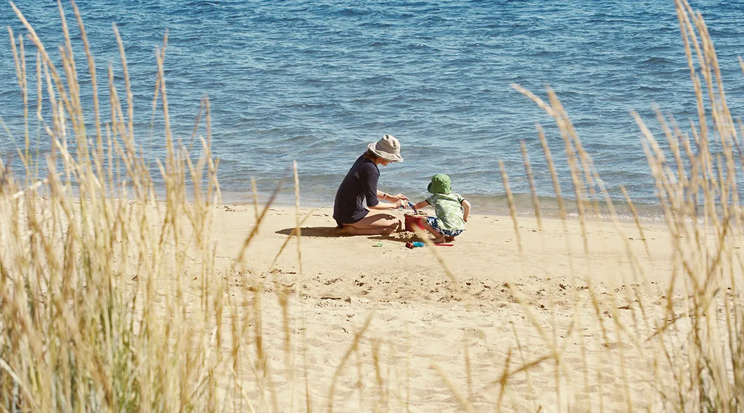 Kuvassa on nainen ja poika rannalla