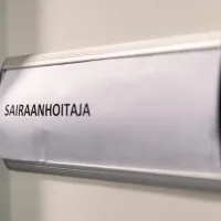 Ovikyltti, jossa lukee &quot;sairaanhoitaja&quot;. 