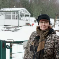 Lastenhoitaja Anna Vieru poseeraa Malminkartanossa talvisen päiväkoti Metsätähden edessä.