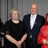 Kolme naista ja mies seisovat vierekkäin ja hymyilevät.