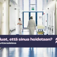 Sairaalan käytävä, kaksi hoitajaa kävelee kauempana käytävällä. 