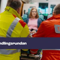 Kuvassa kaksi ensihoitajaa työntää potilasta ambulanssiin. Kuvassa on myös teksti "förhandlingsrundan".