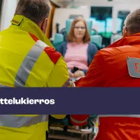 Kaksi ensihoitajaa työntävät potilasta ambulanssiin.