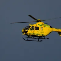 Kuvassa keltainen helikopteri lentää taivaalla.