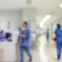 Hoitajat kävelevät sairaalan käytävällä.