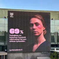 Nyrkkisääntö-kampanjan mainos Musiikkitalon seinällä Helsingissä.