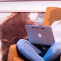 henkilö istuu nojatuolissa kannettava tietokone sylissä