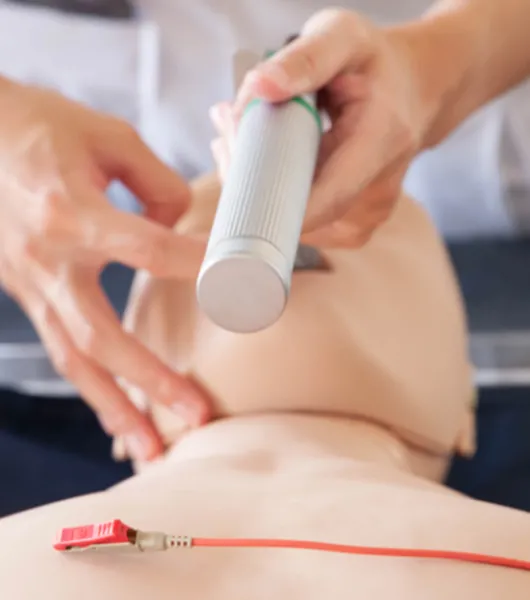 Henkilö laittaa endotrakeaalisen intubaatioputken harjoitusnuken suuhun.