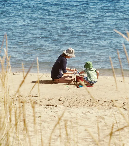 Kuvassa on nainen ja poika rannalla
