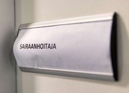 Ovikyltti, jossa lukee &quot;sairaanhoitaja&quot;. 