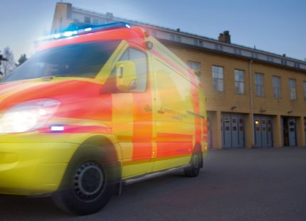 Ambulanssi ajaa kameran ohi, kuva epäselvä. 