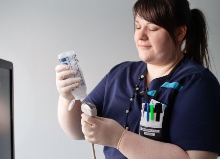 Maksahoitaja Johanna Salmivuori työasussaan työpaikallaan.