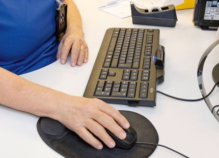 Hoitaja näyttöpäätteen ja näppäimistön ääressä. Chat-vastaanotto helpotti hoitoon pääsyä.