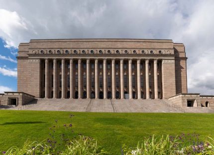 Eduskuntatalo kuvatutna ulkoapäin keväisessä maisemassa.