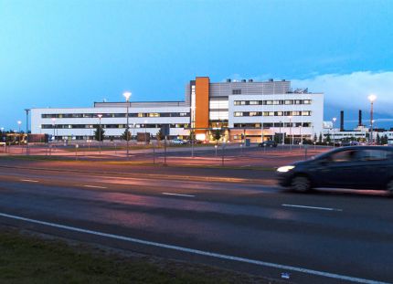 Seinäjoen keskussairaala ulkoapäin kuvattuna. Auto ajamassa rakennuksen ohi.
