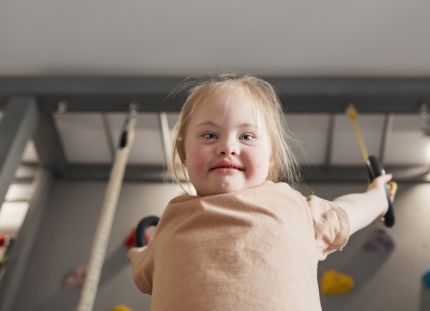 Kehitysvammaliiton ja Autismiliiton toiminta on vaarassa loppua kokonaan hallituksen sotejärjestöjen leikkauksien vuoksi. Nuori kehitysvammainen tyttö leikkii voimistelurenkaissa.