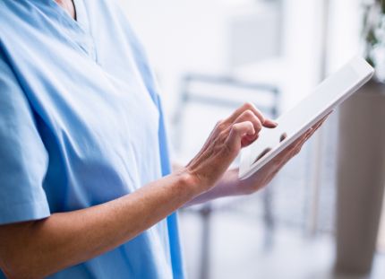 15 sairaanhoitajaa täydensi tutkintoaan suomalaisia osaamisvaatimuksia vastaavaksi Hämeen ammattikorkeakoulussa osana valtakunnallista SAILA-hanketta. Sairaanhoitaja katsoo tabletilta tietoja.