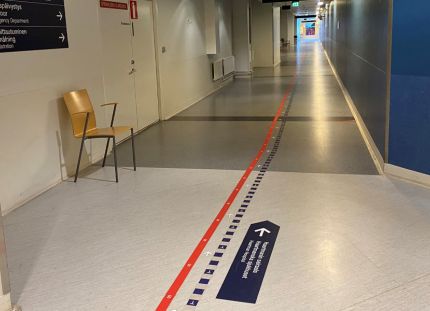 KT:n selvityksen mukaan hyvinvointialueilta puuttuu 735 lääkäriä ja hammaslääkäriä sekä satoja hoitajia. Kuva tyhjästä sairaalan käytävästä. Lattiassa viivoja ohjaamassa kulkureittejä.