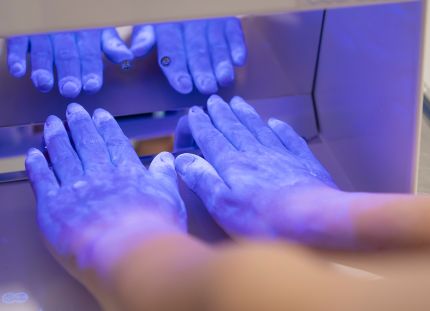 Black box laite, jolla ultraviolettivalon avulla katsotaan ovatko kädet puhtaat.