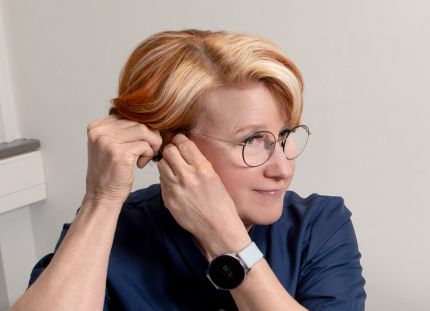 Sairaanhoitaja Leila Hällfors laittaa korvaansa kuulolaitetta.
