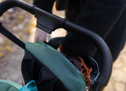 Henkilö työntää lastenvaunuja. Kuvassa näkyy vaunujen työntökahva ja työntäjän kädet. Alle 3-vuotiaiden huostaanotot ovat hieman lisääntyneet.