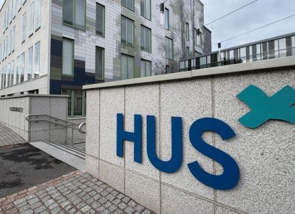 Hus vei yli 500 hoitajan palkanalennukset työtuomioistuimeen. Husin logo rakennuksen kivisessä seinässä.