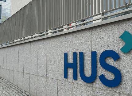 Hus-logo rakennuksen seinässä. Tehy vie Husin palkkasotkut työtuomioistuimeen