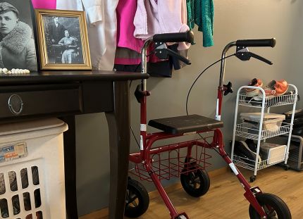 Koti, jossa on vanhoja valokuvia ja rollaattori.