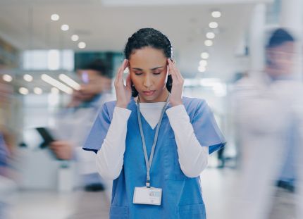 Sairaanhoitaja hälinää täynnä olevassa työympäristössä. 