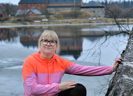 Marika Orava ulkoiluvaatteissa, taustalla Hämeen linna.