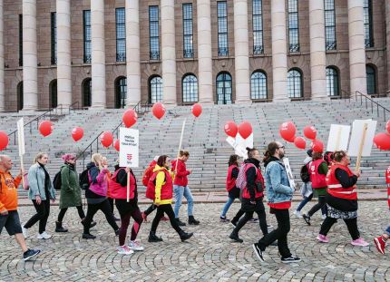 Tehyläiset marssivat eduskuntatalon ohi.
