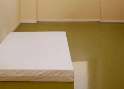 Sairaalan suljetun osaston huone, jossa lattialla pelkkä patja.