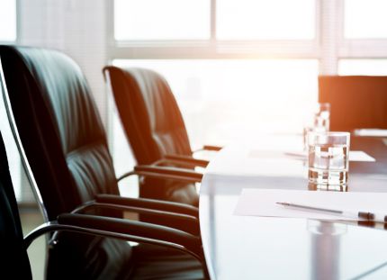 Neuvottelupöydän ääressä mustia nahkatuoleja.