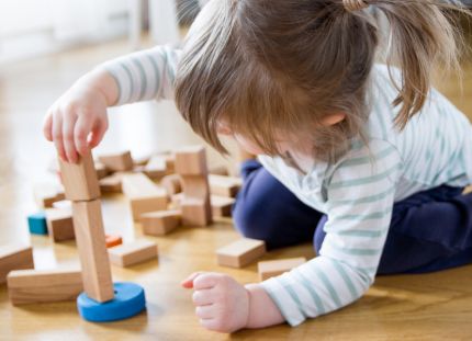 Puisen päiväkodin akustiikka ja sisäilma saavat käyttäjiltä kiitosta. Lapsi leikkii puisilla rakennuspalikoilla.