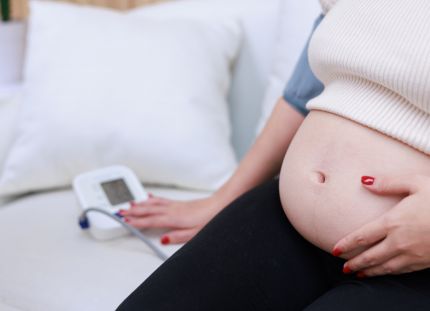 Raskaana oleva nainen mittaa verenpainettaan.