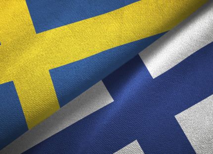 Hoitotyön sanastoa ja fraaseja voi harjoitella suomeksi ja ruotsiksi uudella hoitokieli.fi-sivustolla. Kuvassa kankaiset suomen ja ruotsin liput.