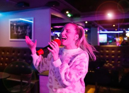 Emmi Bogdanoff laulaa karaokebaarissa.