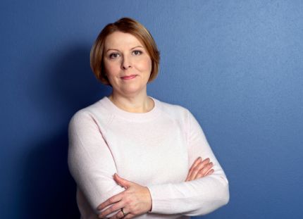 Tehyn toiminnanjohtaja sekä edunvalvontajohtaja Else-Mai Kirvesniemi katsoo hymyillen kameraan sinistä taustaa vasten.