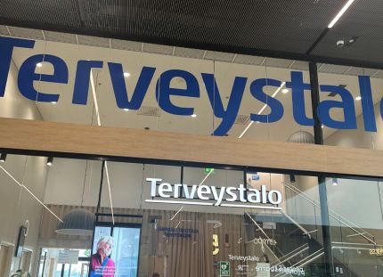 Terveystalon logo rakennuksen seinällä.