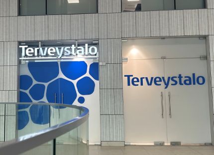 Terveystalon logo rakennuksen seinällä.