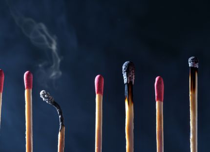 Tulitikkuja rivissä kuvaamassa työssä jaksamista ja uupumista. Välissä on palaneita tikkuja.