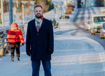 Ensihoitaja Aapo Liukko talvisessa kaupunkilimjöössä vilkkaan autotien vieressä.