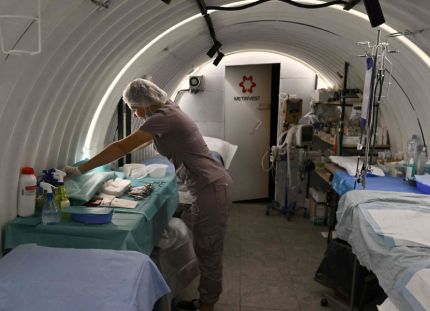 Sairaanhoitaja valmistaa välineitä leikkaussalissa Ukrainan rintaman alla sijaitsevassa maanalaisessa sairaalassa.