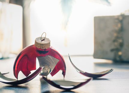 Rikkinäinen joulupallo lattialla.