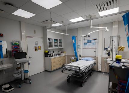 Varkauden yöpäivystyksestä kuva. Hoitohuoneessa sermi, sänky, tietokone ja laitteita.