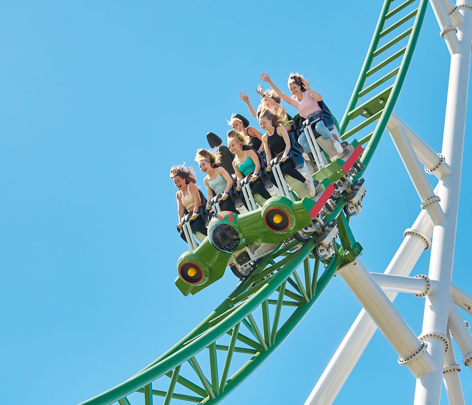 Huvipuistossa ihmiset vuoristoradassa 