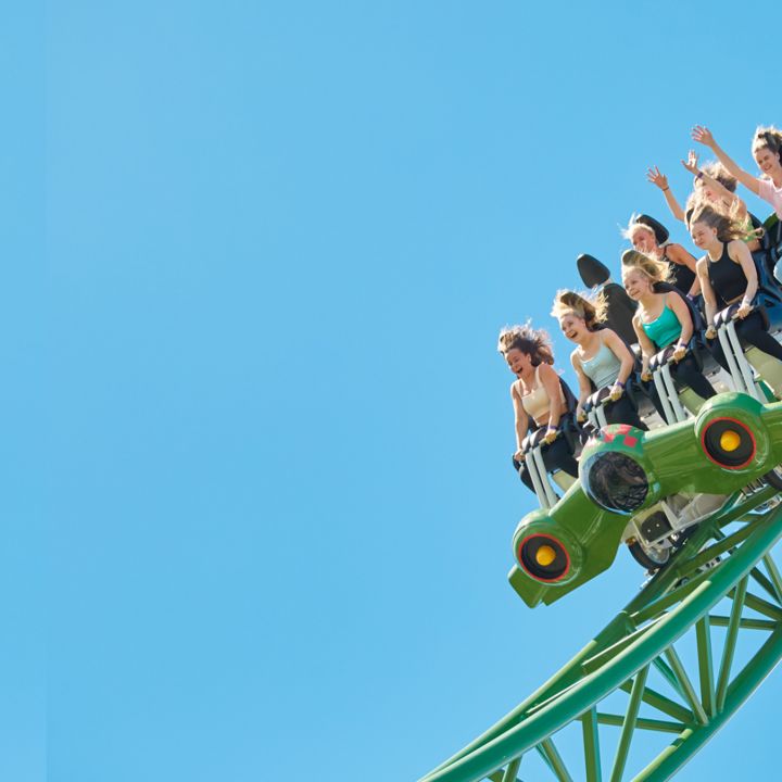 Huvipuistossa ihmiset vuoristoradassa 