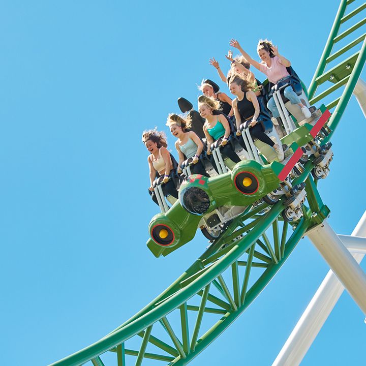 Huvipuistossa ihmiset vuoristoradassa 